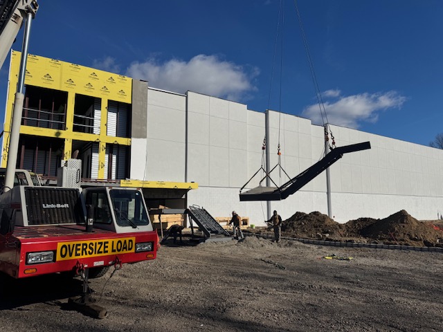 Fabricated steel stair flight being handled by crane at Armonk