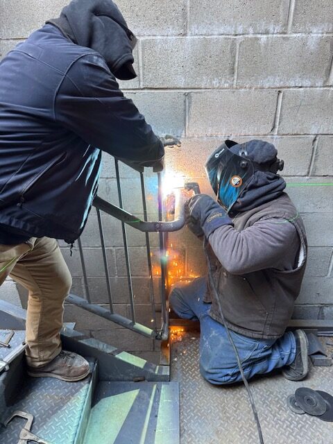 Field fitting and welding of a steel stair handrail at Armonk